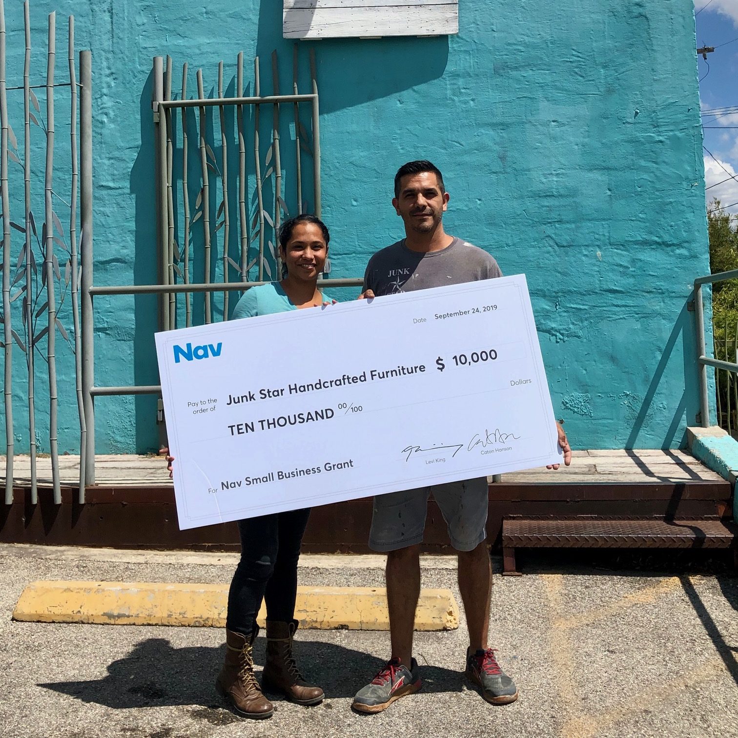 Business owners holding a giant check