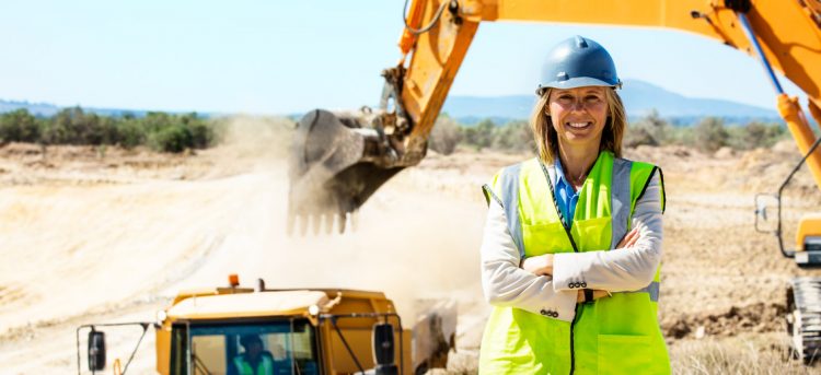 Portrait of confident female architect standing arms crossed at quarry against clear sky